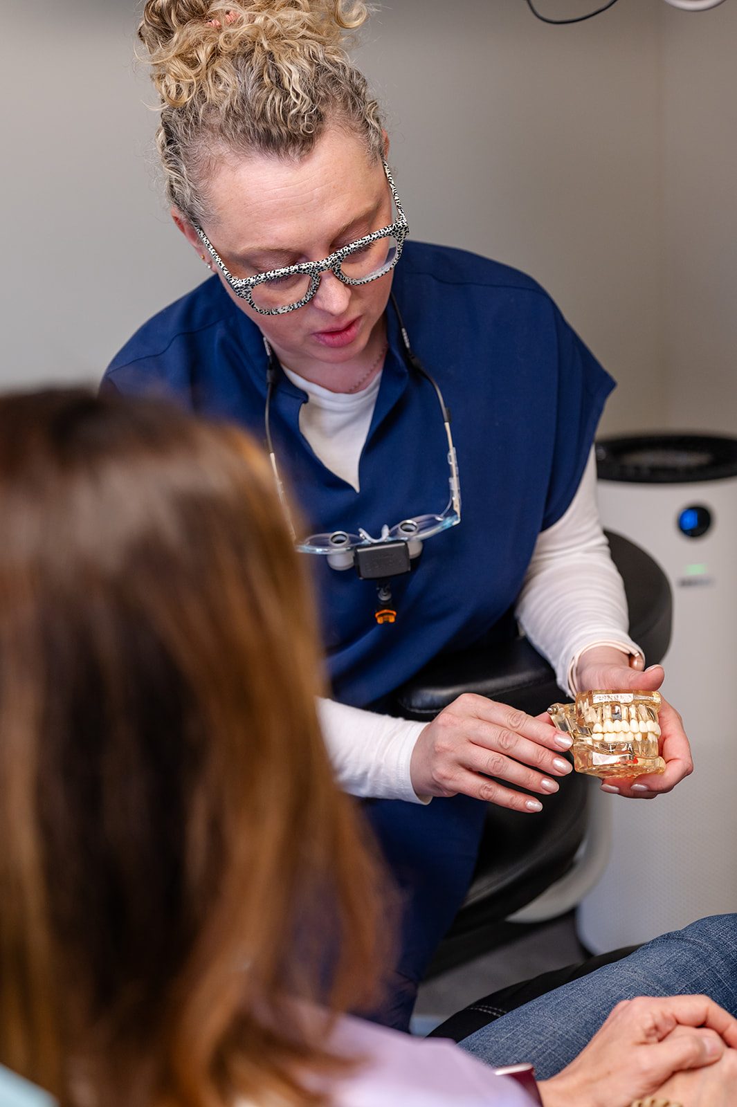 A dentist showing a patient how dental implants restore a missing tooth
