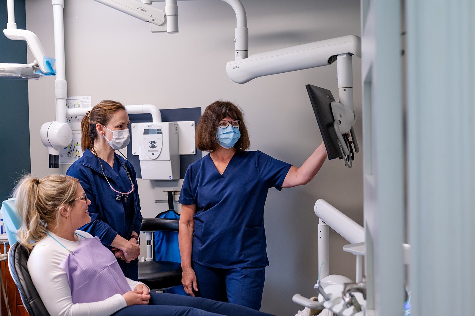 The Dearness dental team reviewing a digital x-ray with a patient in the treatment room
