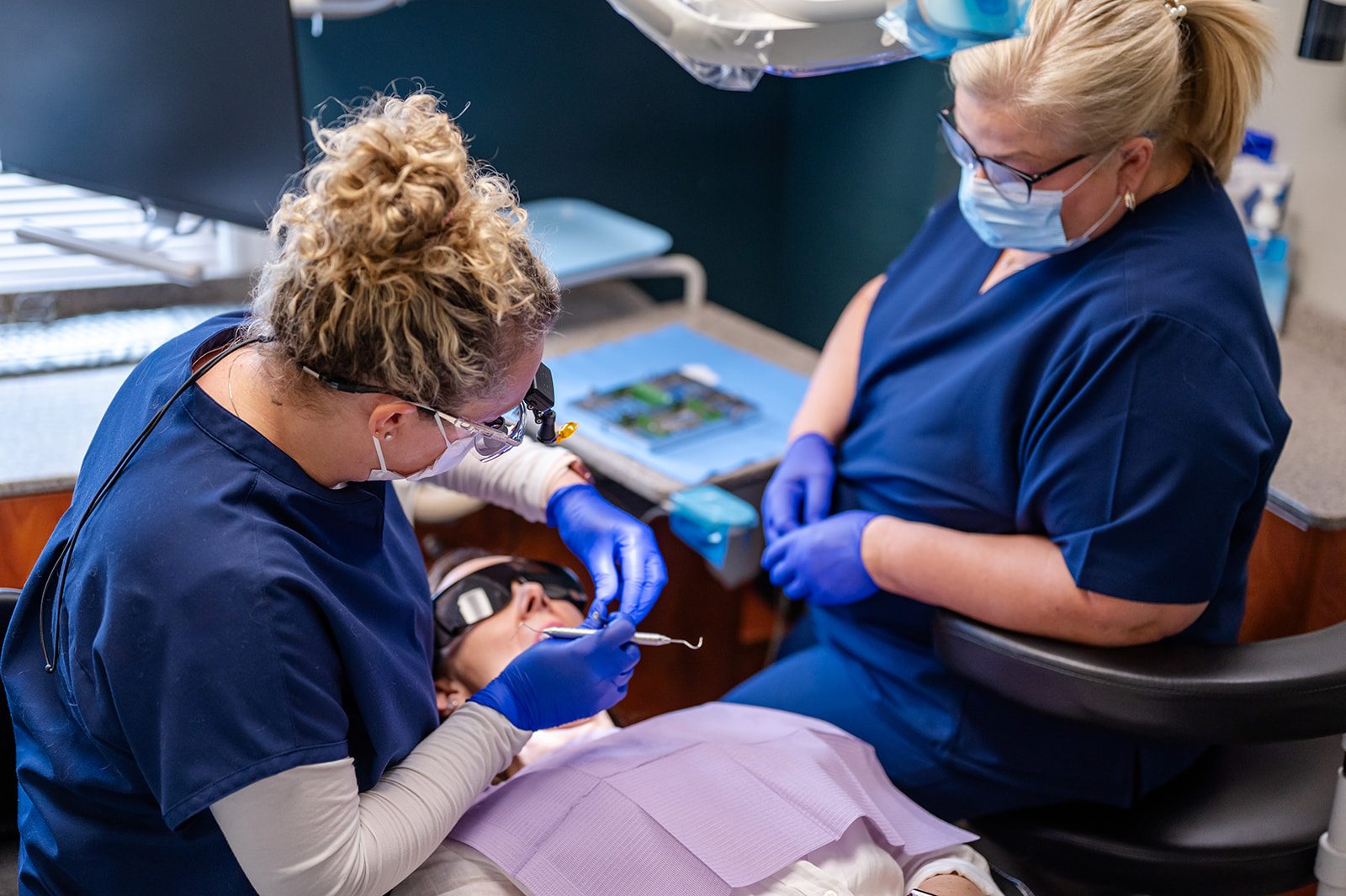 A dentist and hygienist providing periodontal care in the treatment room
