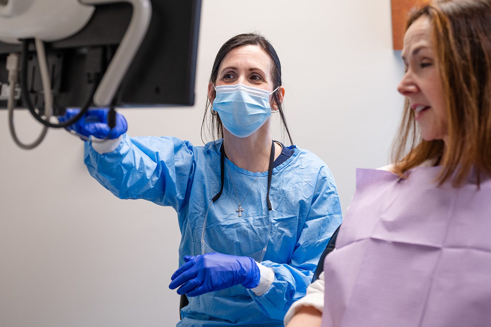 A team member reviewing whitening progress with a patient on the treatment-room monitor